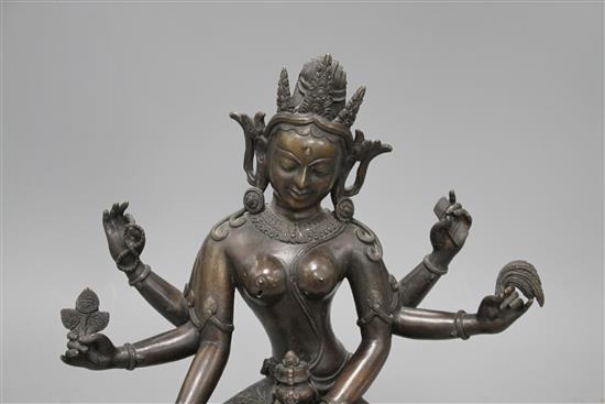 A Sino-Tibetan bronze figure of a seated female deity, on associated marble plinth, height 35cm